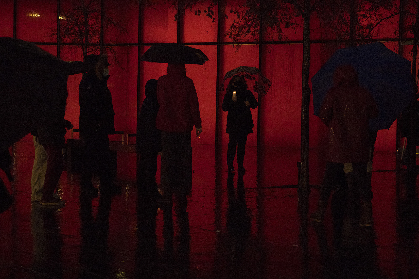 caption: Outreach worker Rebecca Gilley, center, holds a candle during the WHEEL Women in Black vigil for the record-breaking 139 houseless people who’ve died outside, in public or by violence this year in King County on Monday, December 21, 2020, at Seattle City Hall. 