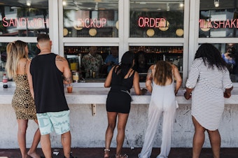 caption: Customers at this take-out window in Miami on March 20 were not practicing social distancing.