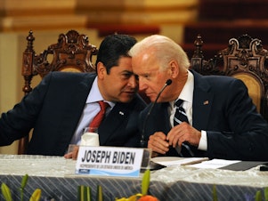 caption: Honduran President Juan Orlando Hernández (left) speaks with then-Vice President Biden during a news conference in Guatemala City on March 2, 2015. Leaders from Guatemala, El Salvador and Honduras were meeting with Biden for two days of talks about child migrants entering the United States.
