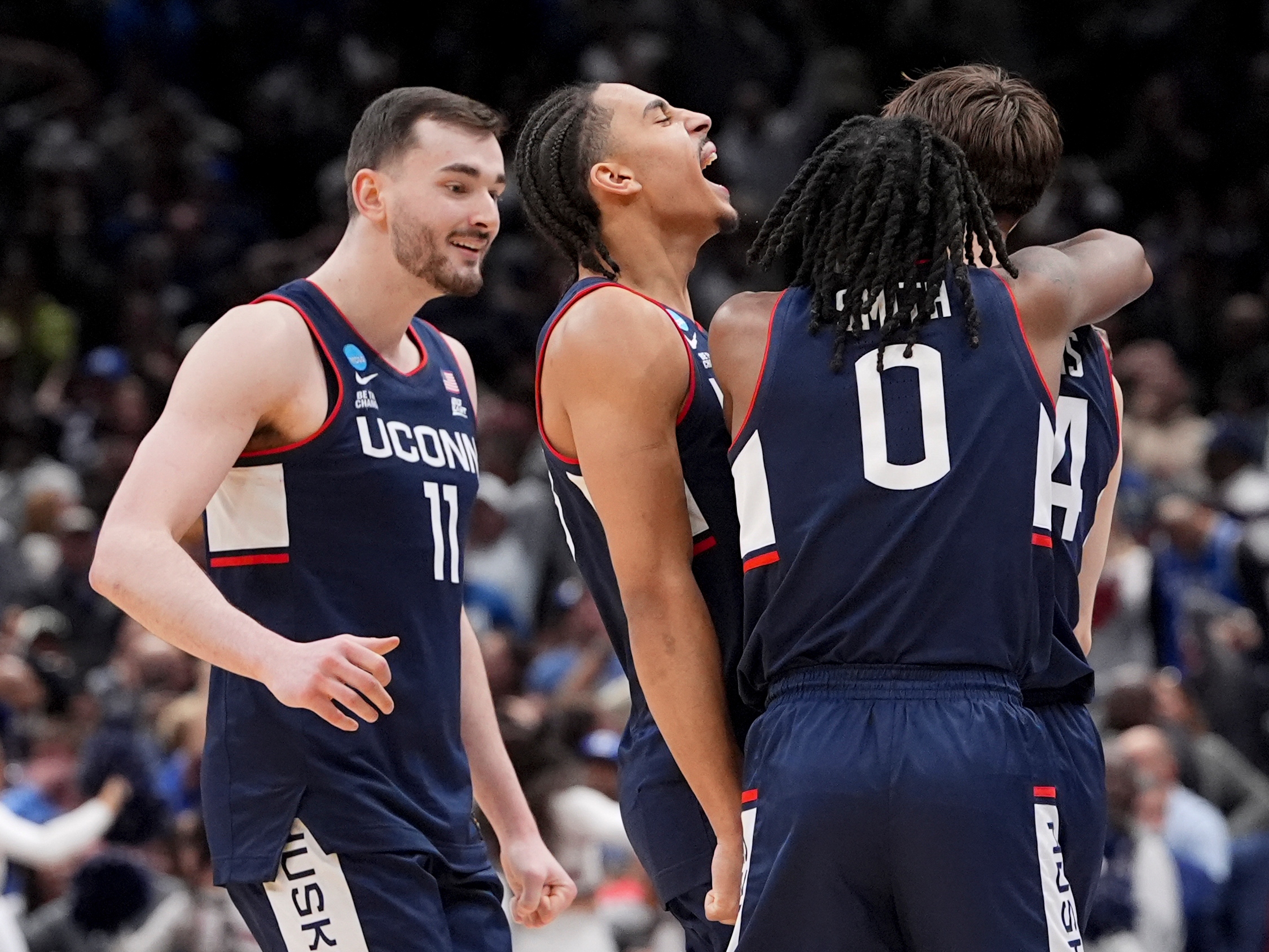 caption: UConn guard Braylon Mullins, right, celebrates his game winning basket with guard Malachi Smith (0) during the second half in the Elite Eight of the NCAA college basketball tournament against Duke, Sunday, March 29, 2026, in Washington.