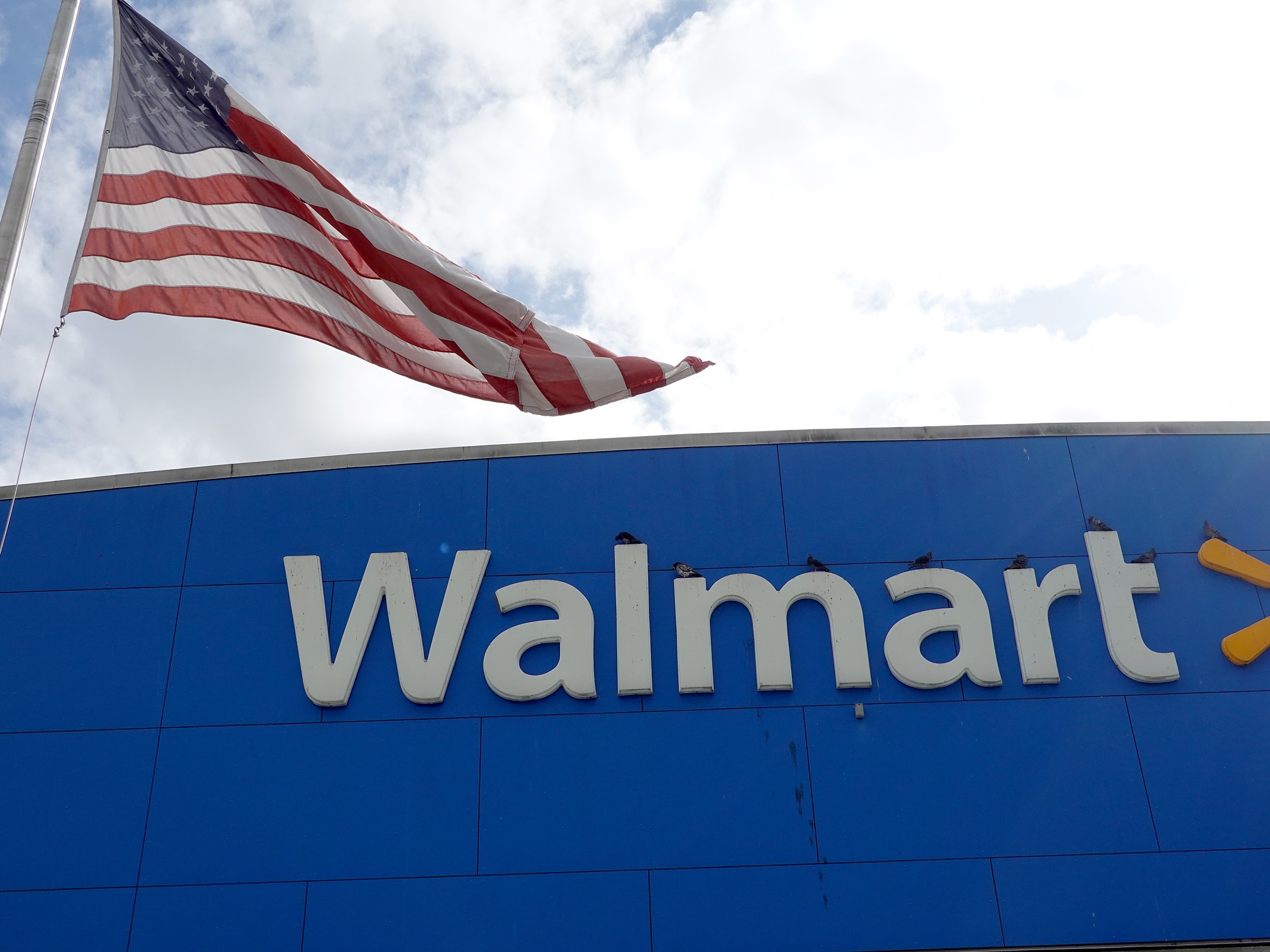 caption: An American flag flies outside a Walmart store in Miami. In 2020, Walmart was one of many large U.S. companies that pledged to fight racism and increase internal diversity. But now it, Amazon, Facebook and many other companies are ending some of those programs.