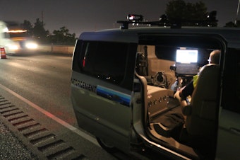 caption: An officer works in a speed enforcement van along I-5 in Medford during construction in 2018. The effort to slow drivers nabbed one driver going 91 mph in the 40 mph work zone.