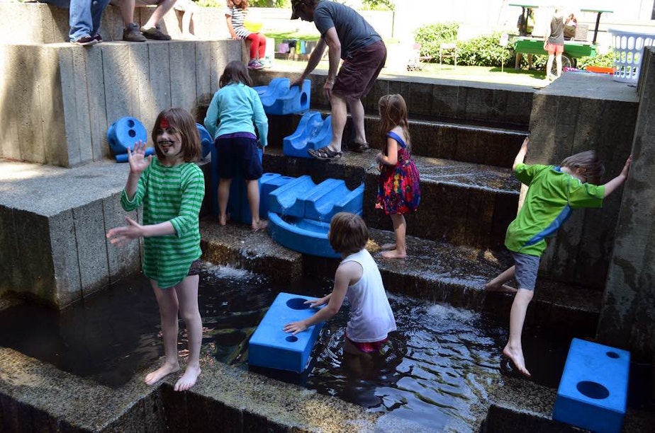 caption: File photo: Children splash in a fountain in Freeway Park in downtown Seattle.