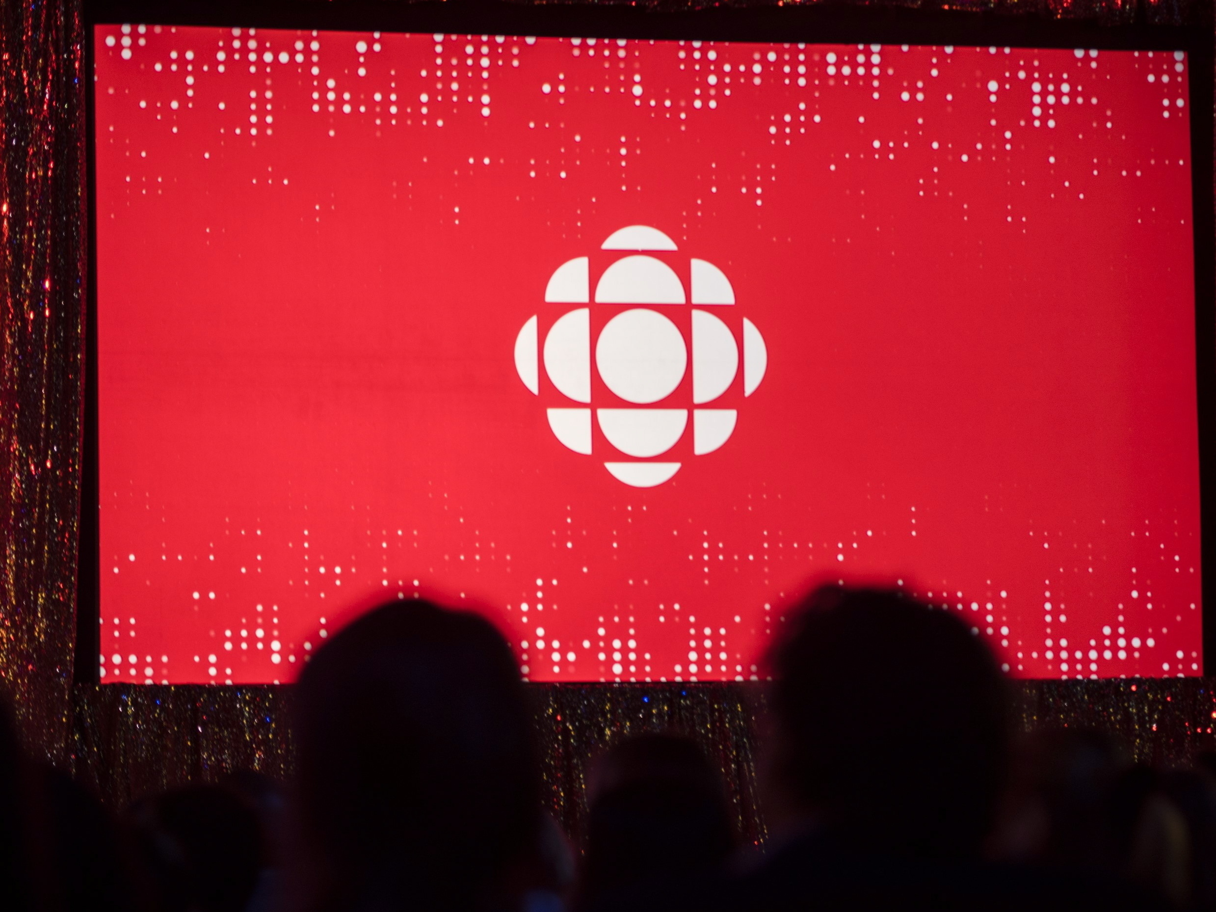 caption: The Canadian Broadcasting Corporation logo is projected onto a screen on May 29, 2019, in Toronto.