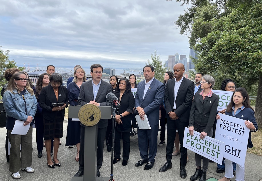caption: In Seattle on June 13, 2025, Washington Gov. Bob Ferguson and local officials urged people to protest Trump's policies but do so nonviolently.