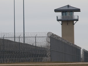 caption: A guard tower and prison yard at the Thomson Correctional Center in Thomson, Ill., in 2009. Five men have been killed at Thomson since 2019, making the facility one of the deadliest federal prisons in the country.