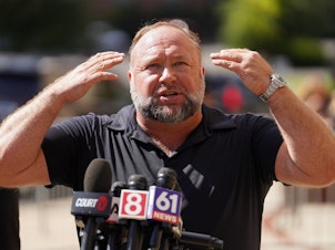 caption: InfoWars founder Alex Jones speaks to the media outside Waterbury Superior Court during his trial on Sept. 21, 2022 in Waterbury, Conn.