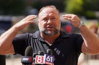 caption: InfoWars founder Alex Jones speaks to the media outside Waterbury Superior Court during his trial on Sept. 21, 2022 in Waterbury, Conn.