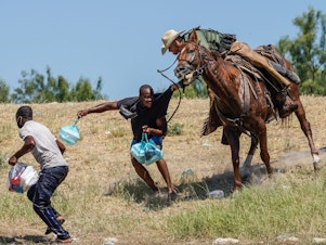 caption: A U.S. Border Patrol agent on horseback tries to stop a Haitian migrant from entering an encampment on the banks of the Rio Grande near the Acuña Del Rio International Bridge in Del Rio, Texas.