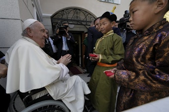 caption: Children in traditional dress welcome Pope Francis arriving for a meeting with charity workers and for the inauguration of the House of Mercy in Ulaanbaatar, Monday, Sept. 4, 2023.
