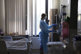 caption: A nurse administers care to a patient in the acute care COVID unit at Harborview Medical Center on May 7, 2020 in Seattle, Washington. (Karen Ducey/Getty Images)
