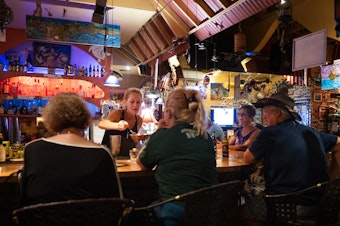 caption: Cori Gross, bartender at Java Jazz, greets residents with bursts of joy to see that they've survived the fires.