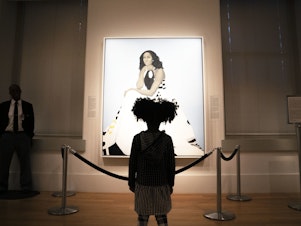 caption: Parker Curry, 4, takes in Amy Sherald's painting of Michelle Obama in the National Portrait Gallery in Washington, D.C. Parker has co-authored a book with her mom called <em>Parker Looks Up: An Extraordinary Moment.</em>