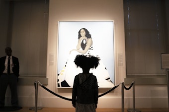 caption: Parker Curry, 4, takes in Amy Sherald's painting of Michelle Obama in the National Portrait Gallery in Washington, D.C. Parker has co-authored a book with her mom called <em>Parker Looks Up: An Extraordinary Moment.</em>