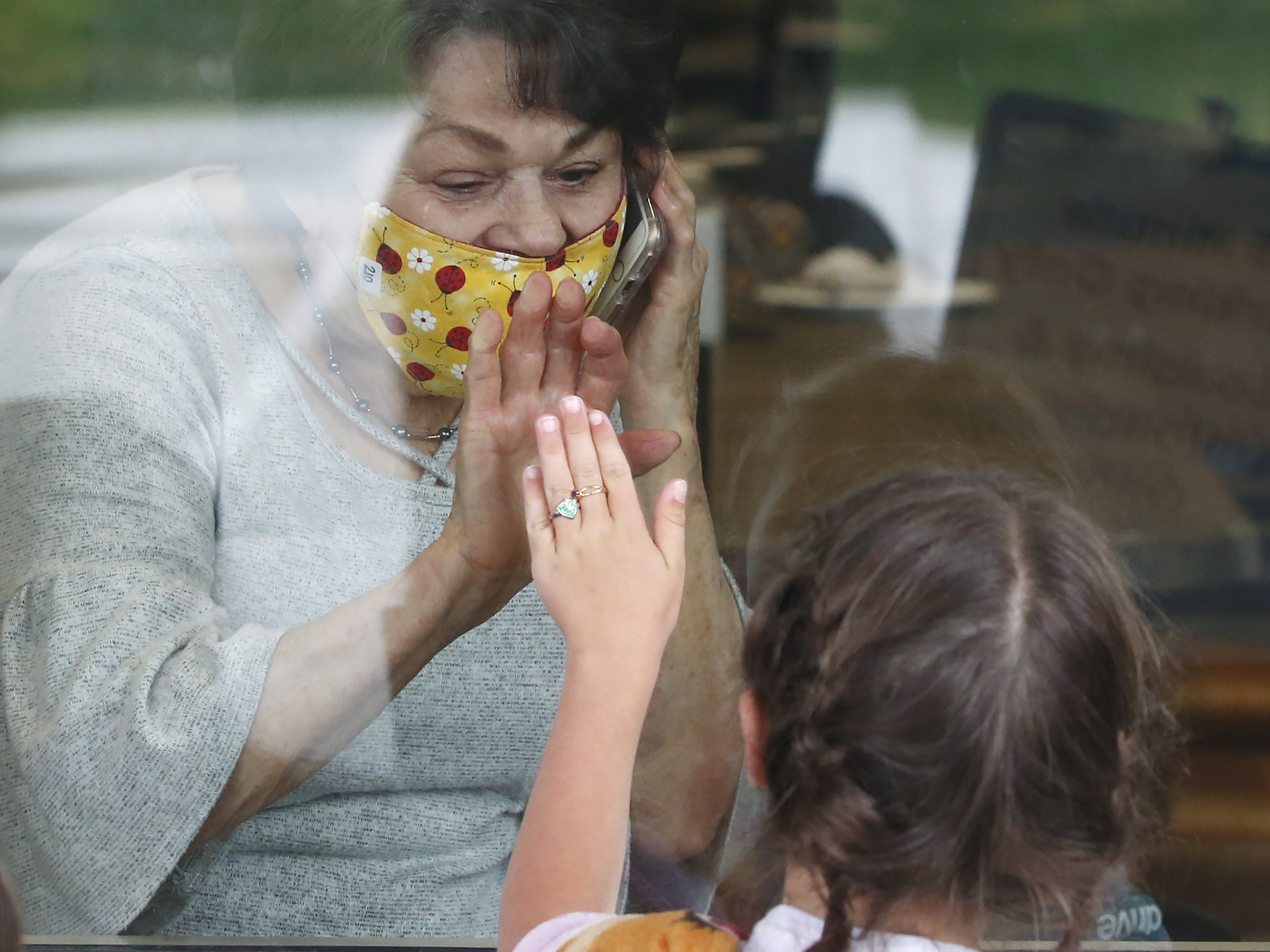 caption: Raelene Critchlow, 86, receives a visit from her great-grandchild Camille Carter, 6, at Creekside Senior Living, Thursday, April 23, 2020, in Bountiful, Utah.
