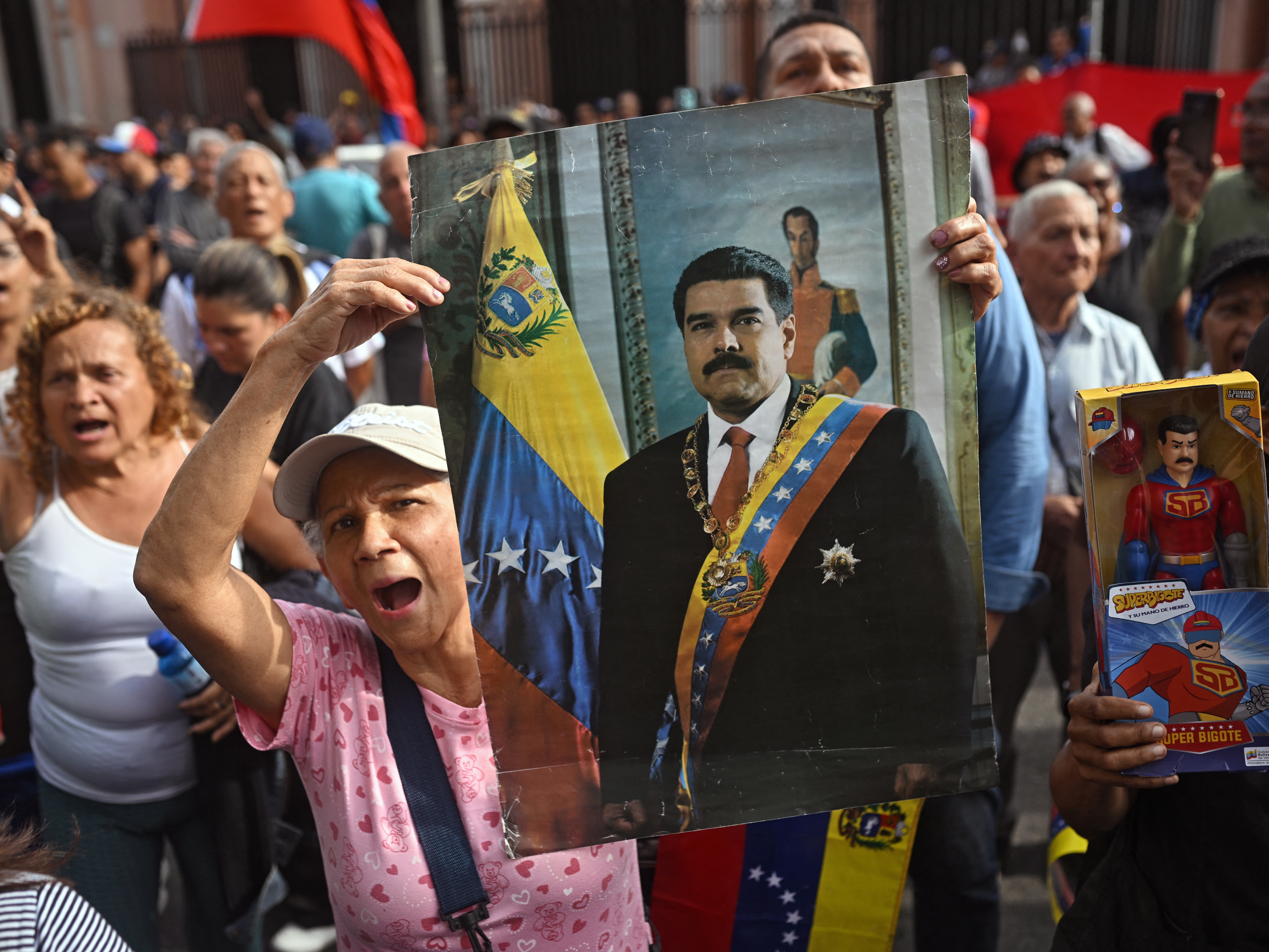 caption: A woman holds a portrait of ousted Venezuelan President Nicolás Maduro in Caracas, Venezuela, on Saturday after he was captured by U.S. forces.
