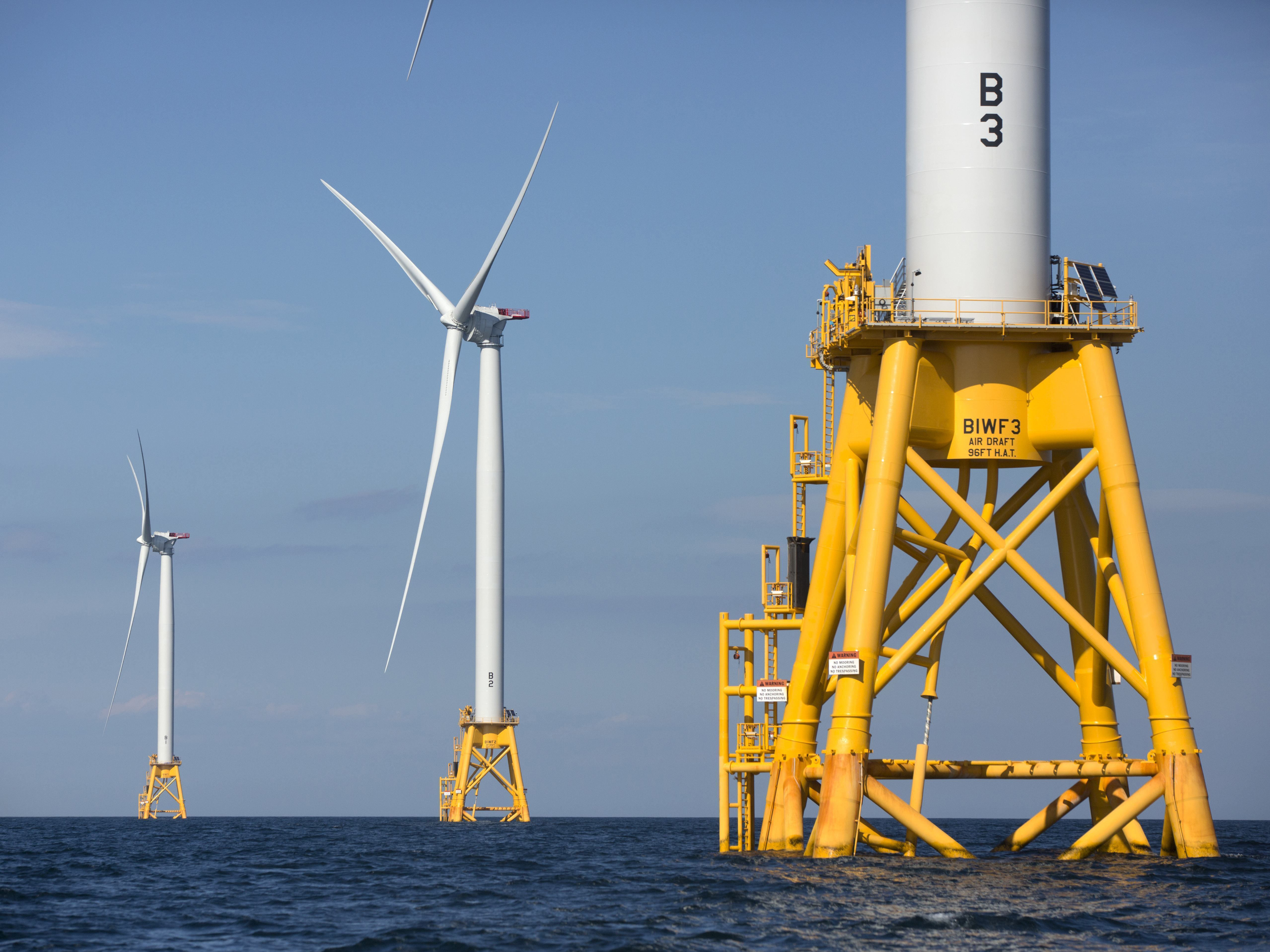 caption: Three of Deepwater Wind's turbines stand off Block Island, R.I., in 2016. The Biden administration is pushing for a sharp increase in offshore wind energy development along the East Coast.