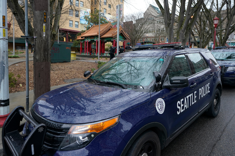 caption: A Seattle Police vehicle sits parked at Hing Hay Park in the heart of Seattle's Chinatown-International District Thursday, March 18, 2021.