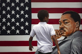 caption: A young boy walks past a painting depicting Dr. Martin Luther King Jr. during a Juneteenth celebration in Los Angeles in 2020. Juneteenth marks the day in 1865 when federal troops arrived in Galveston, Texas, to take control of the state and ensure all enslaved people be freed, more than two years after the Emancipation Proclamation.