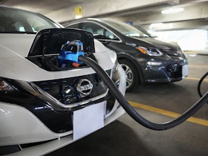 caption: Electric vehicles are displayed at a news conference with White House Climate Adviser Gina McCarthy and Secretary of Transportation Pete Buttigieg in Washington, D.C., on April 22, 2021. The Biden administration's climate and health care bill passed by Congress last week revamps a tax credit for buyers of electric cars.