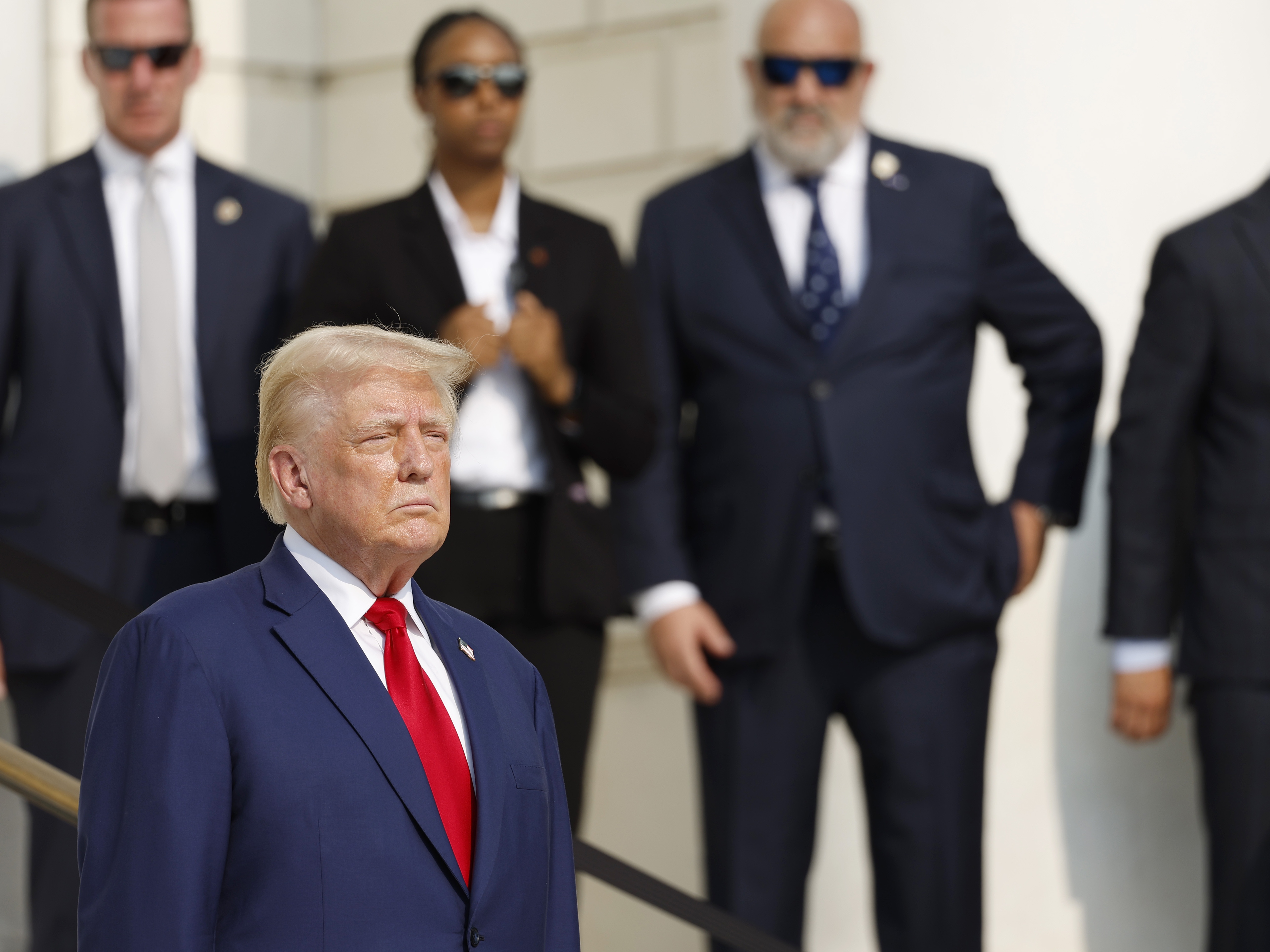 caption: Republican presidential nominee, former President Donald Trump looks on during a wreath laying ceremony at the Tomb of the Unknown Soldier at Arlington National Cemetery on August 26, 2024 in Arlington, Virginia.