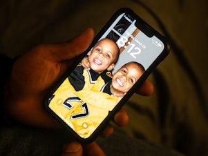 caption: Zion Kelly keeps a screensaver on his phone of he and his brother as young kids.