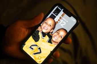 caption: Zion Kelly keeps a screensaver on his phone of he and his brother as young kids.