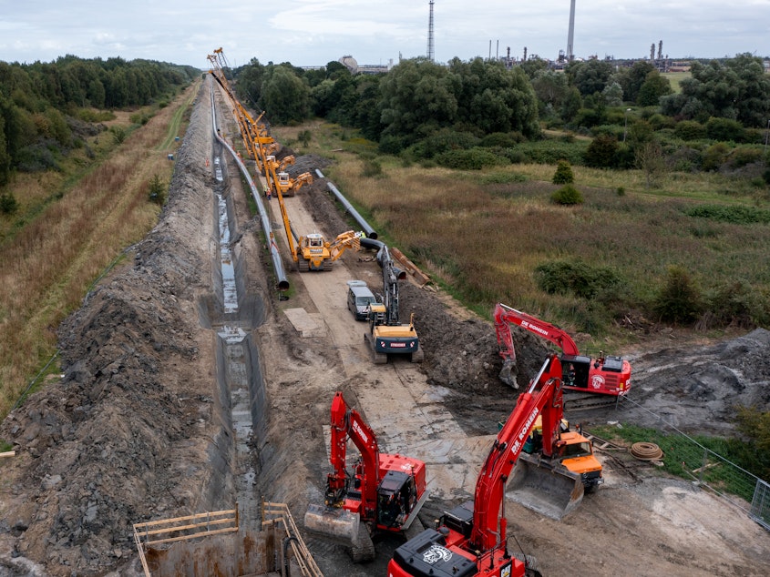 caption: Workers in Germany construct a new pipeline for transporting natural gas imports from a nearby liquified natural gas facility. European countries are seeking new sources of natural gas, as they wean themselves off imports from Russia.