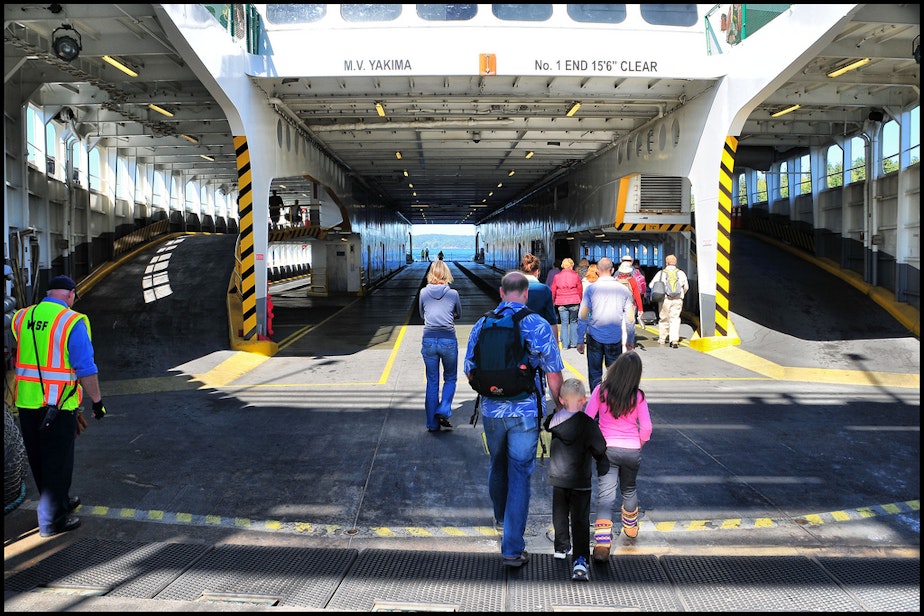 caption: Walk-on passengers board a Washington State Ferry. Passengers who walk on to the ferry can skip the long wait lines for people who are driving on.