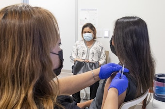 caption: A 16-year-old gets a Pfizer-BioNTech COVID-19 vaccine in Anaheim, Calif., on April 28. Advisers to the Centers for Disease Control and Prevention now say it's not necessary for adolescents to wait two weeks after a COVID shot to receive routine immunizations.