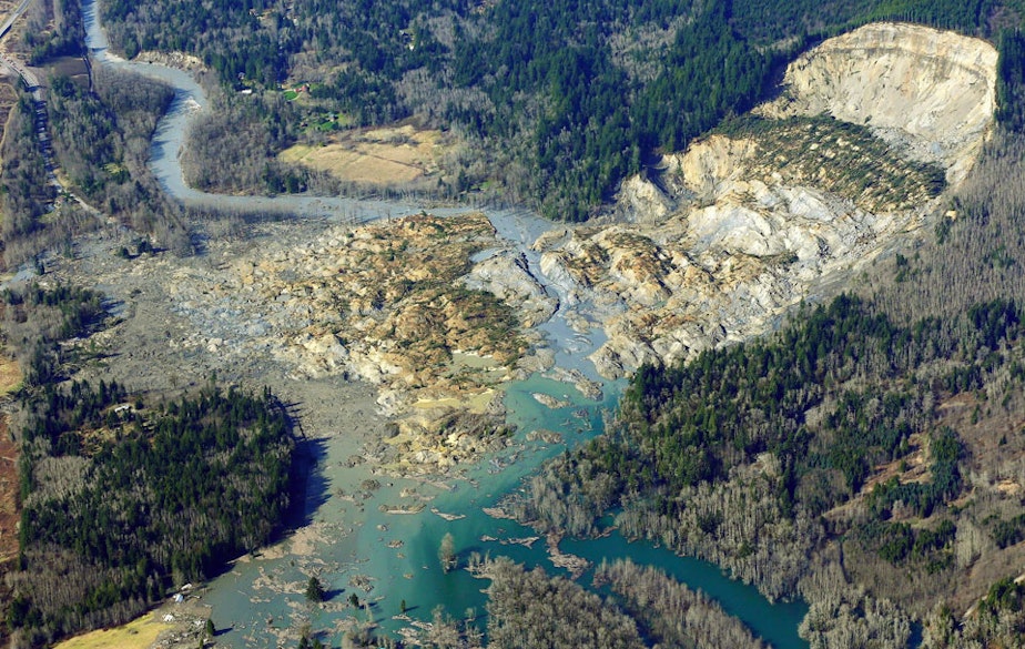 caption: The massive mudslide that killed at least eight people and left dozens missing is shown in this aerial photo, Monday, March 24, 2014, near Arlington, Wash. 