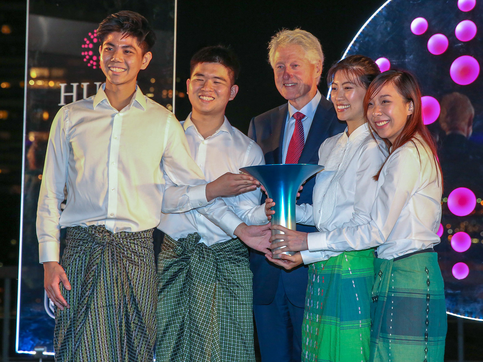 caption: Members of the winning team pose with former President Bill Clinton during the Hult Prize Awards Dinner at U.N. headquarters. From left: Kisum Chan, Lincoln Lee, Julia Vannaxay, Vannie Koay
