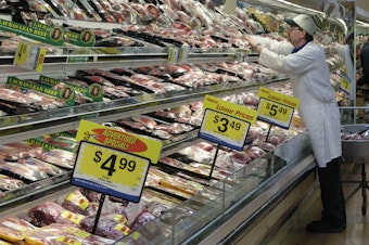 caption: In this March 1, 2011, file photo, a worker stocks the fresh meat shelves at a Kroger Co. supermarket, in Cincinnati. 