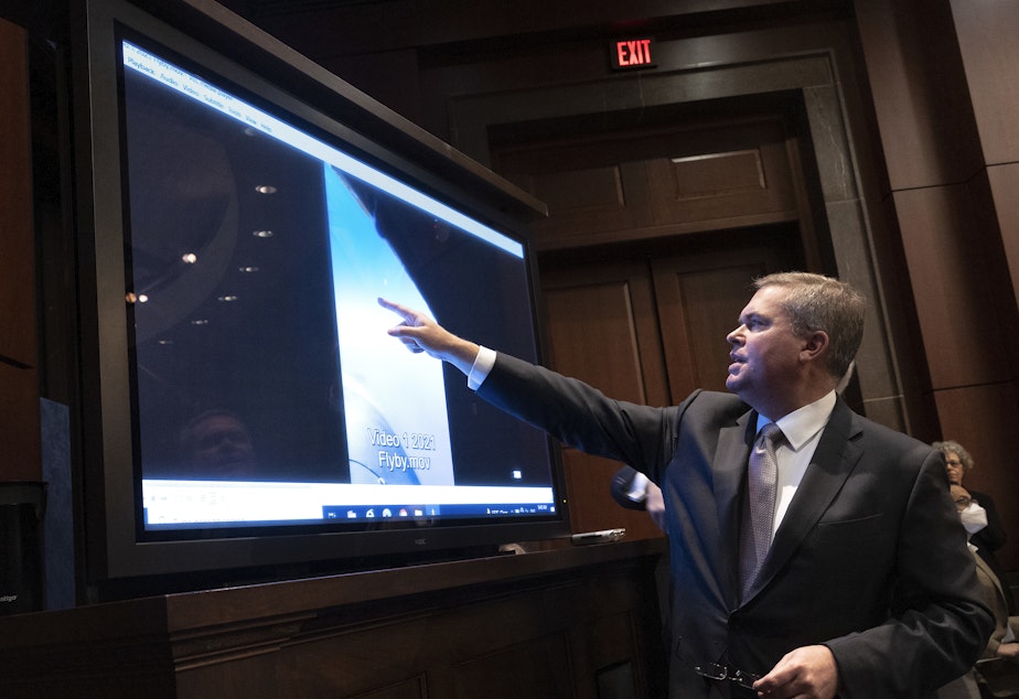 caption: U.S. Deputy Director of Naval Intelligence Scott Bray explains a video of an unidentified aerial phenomena, as he testifies before a House Intelligence Committee subcommittee hearing at the U.S. Capitol on May 17, 2022 in Washington, DC.