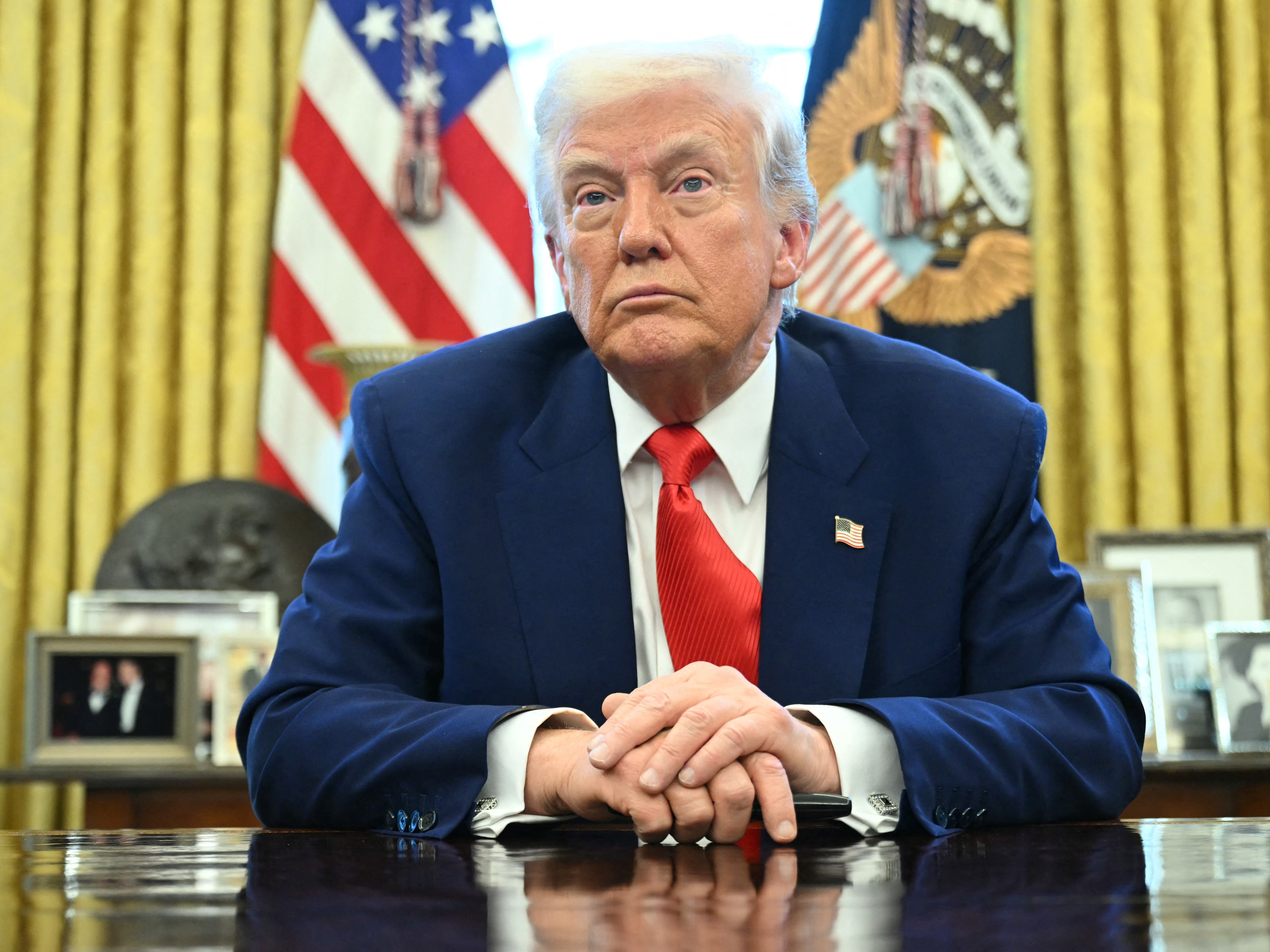 caption: President Trump looks on after signing an executive order in the Oval Office of the White House on April 9, 2025 in Washington, DC.