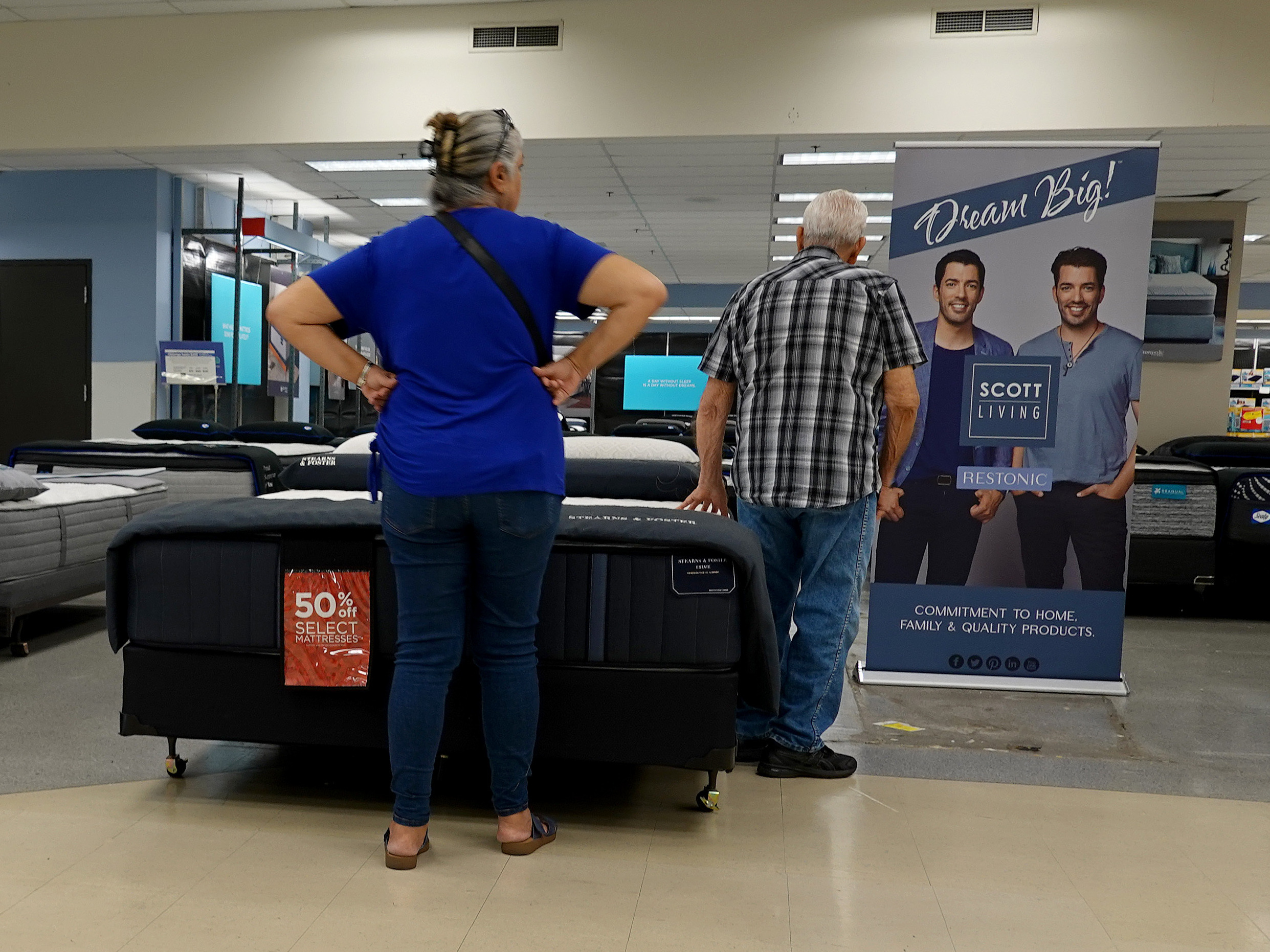 caption: Shoppers look over mattresses at a store in Miami on March 14, 2023.