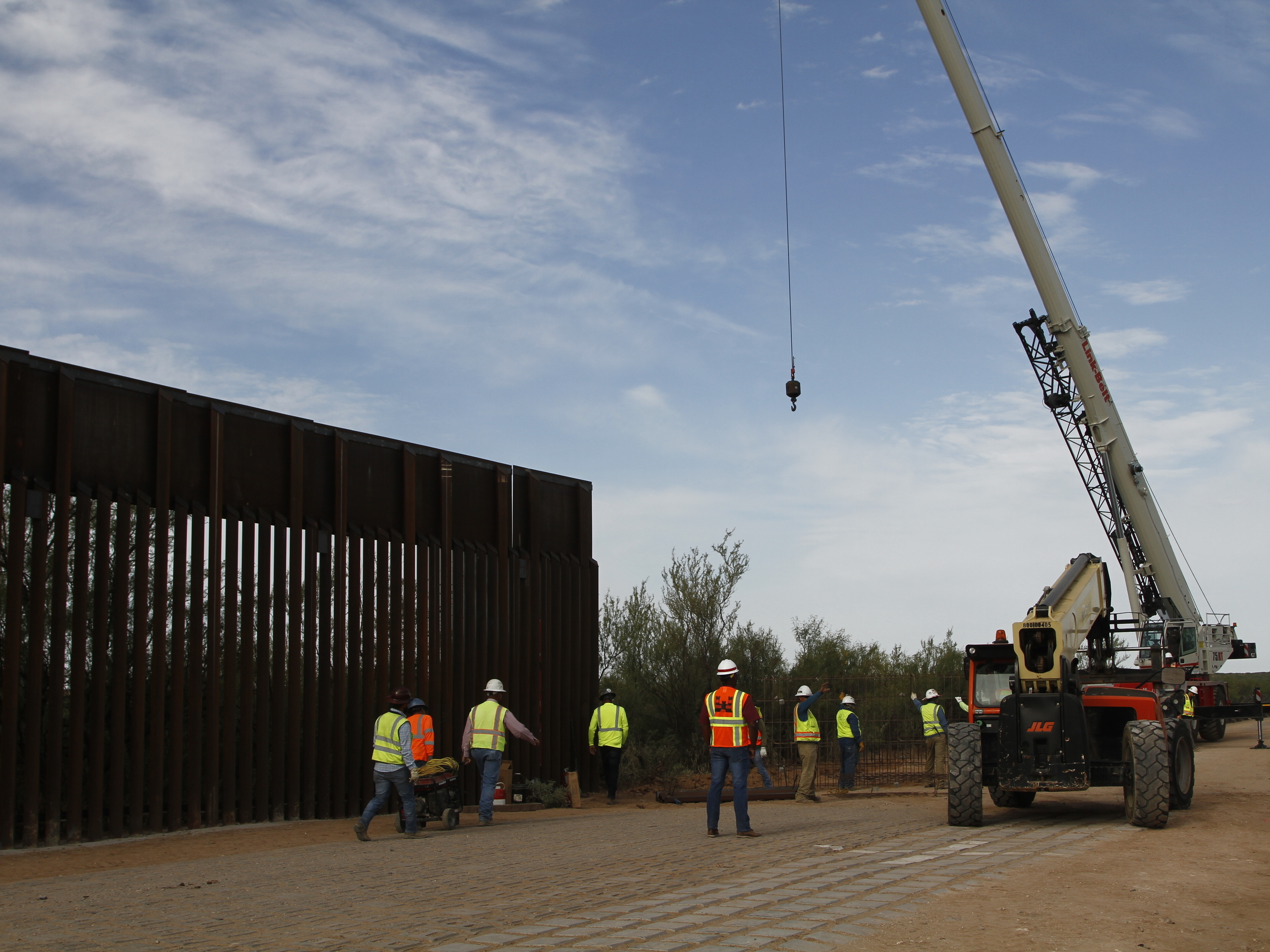 caption: Workers break ground on new border wall construction about 20 miles west of Santa Teresa, N.M., last month. The Trump administration has started the arduous process of canceling $3.6 billion in military construction projects to fund its plans to build more of a wall along the U.S.-Mexico border.