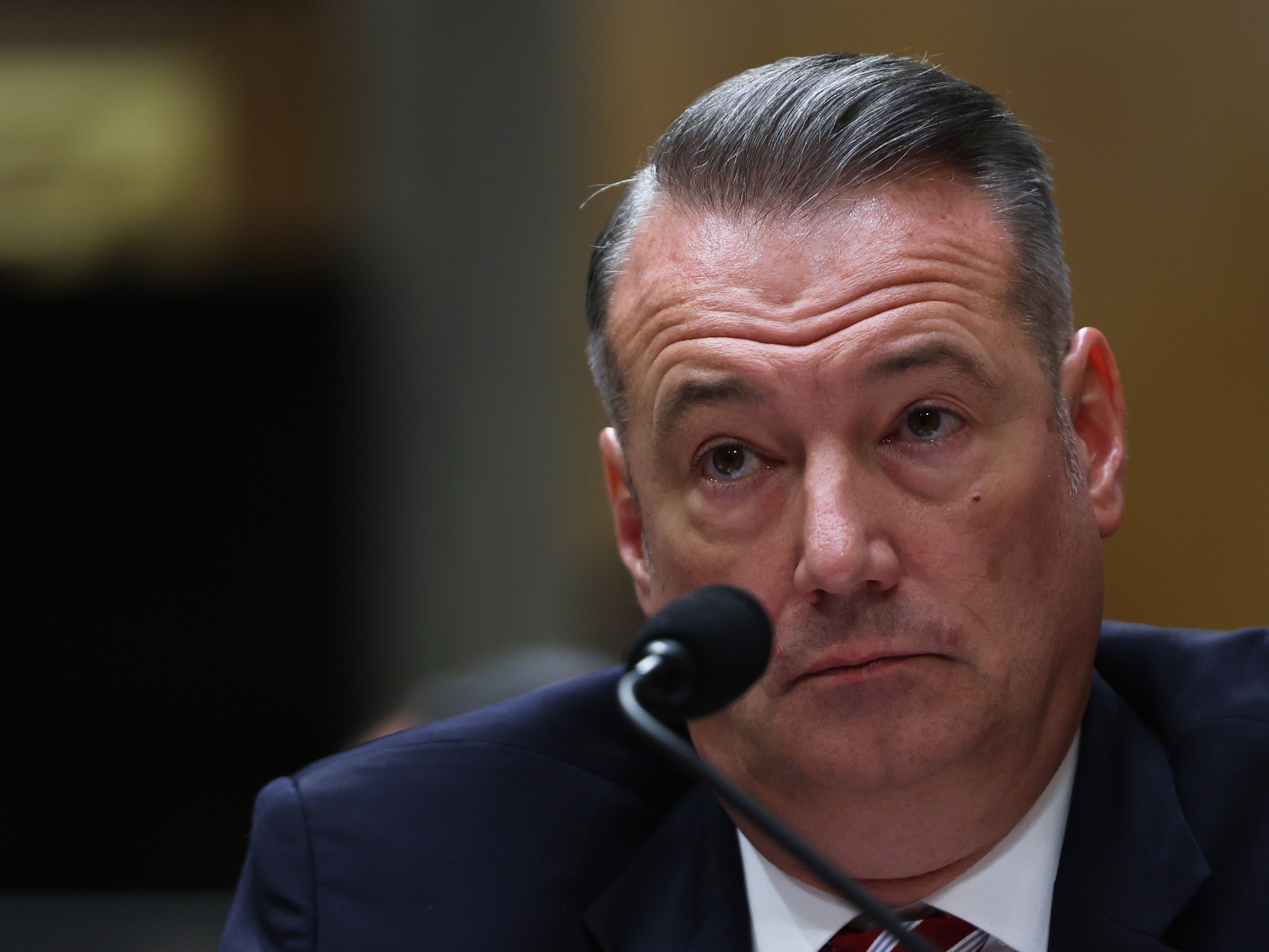 caption: FILE - Todd Lyons, senior official performing the duties of the director at U.S. Immigration and Customs Enforcement, listens during a Senate Homeland Committee hearing on Capitol Hill in Washington, Feb. 12, 2026.