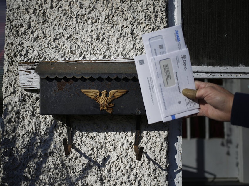 caption: A U.S. Postal Service letter carrier delivers the mail in Shelbyville, Ky. A White House task force recommended ending the mailbox monopoly held by USPS.CREDIT: Luke Sharrett/Bloomberg via Getty Images