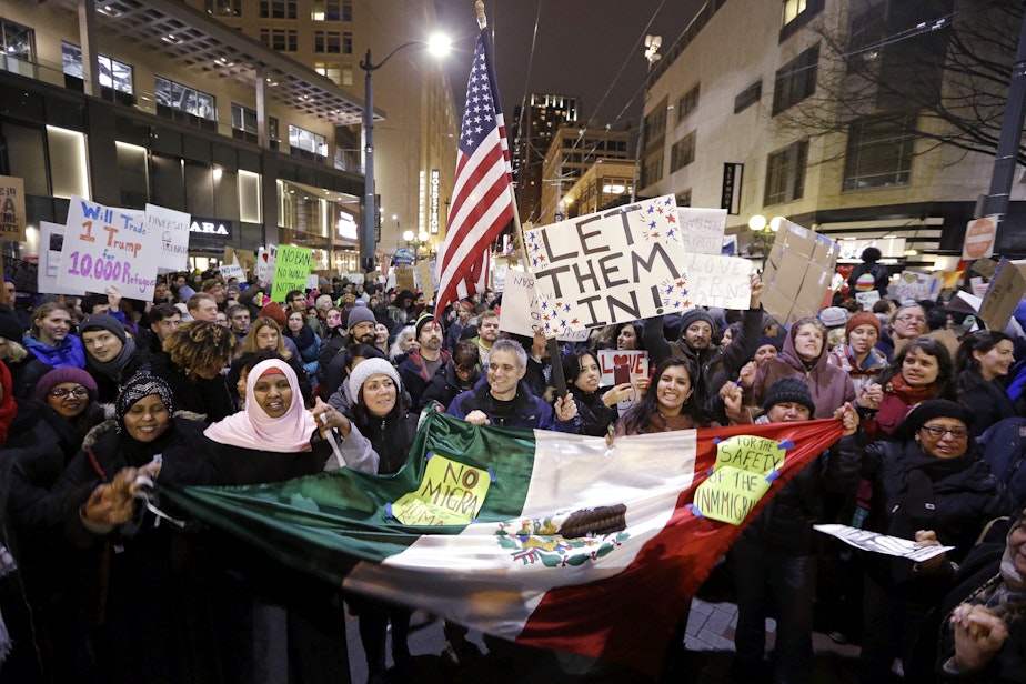caption: People cheer during a rally to oppose President Donald Trump's executive order barring people from certain Muslim nations from entering the United States, Sunday, Jan. 29, 2017, in downtown Seattle. 