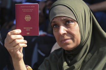 caption: A Palestinian-German woman shows her German passport at the Rafah border crossing between the Gaza Strip and Egypt on Saturday. The crossing point remains closed, but is a potential route for foreign passport holders to leave Gaza, and for humanitarian supplies to enter as the Mideast crisis worsens.