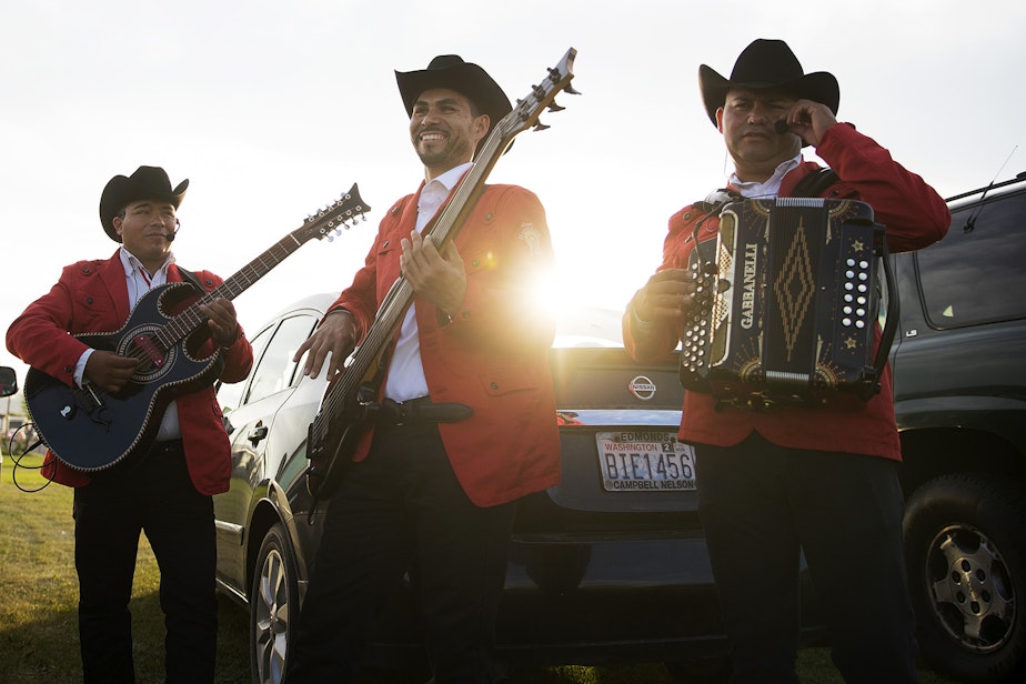 caption: Members of the Grupo Herradura De Plata from left, Fermin Herrera, Everardo Gallardo and Javier Cruz warm up in a parking area before performing during a mass wedding ceremony where 23 couples were married on Sunday, June 2, 2019, at Our Lady of the Desert Church in Mattawa. 