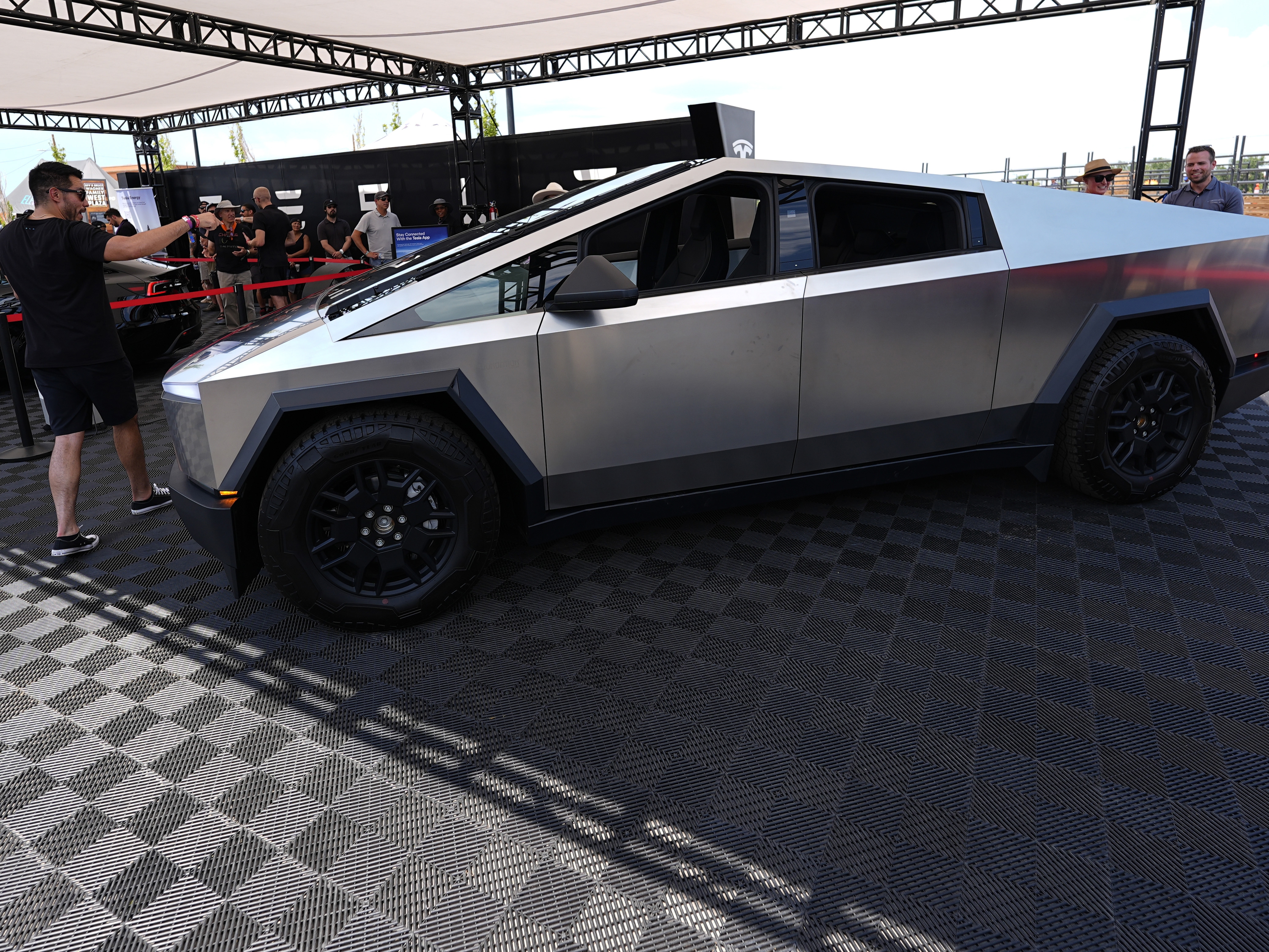caption: Visitors look over a 2024 Cybertruck in the Tesla display at the Electrify Expo, last July.