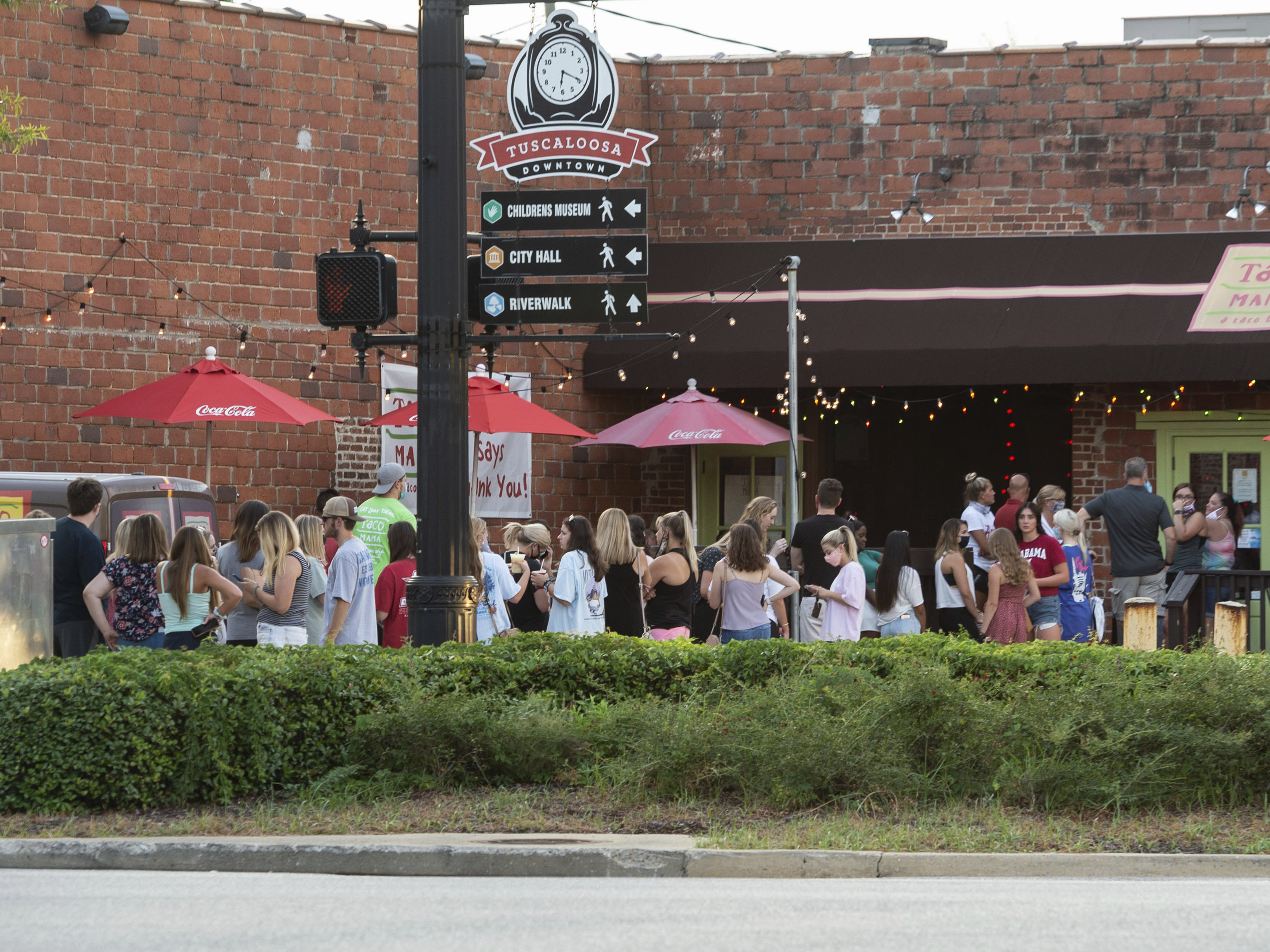 caption: People line up outside to order food from a taco restaurant in Tuscaloosa, Ala. Social media images of crowds outside bars drew scrutiny last weekend in the city, which is home to the University of Alabama.