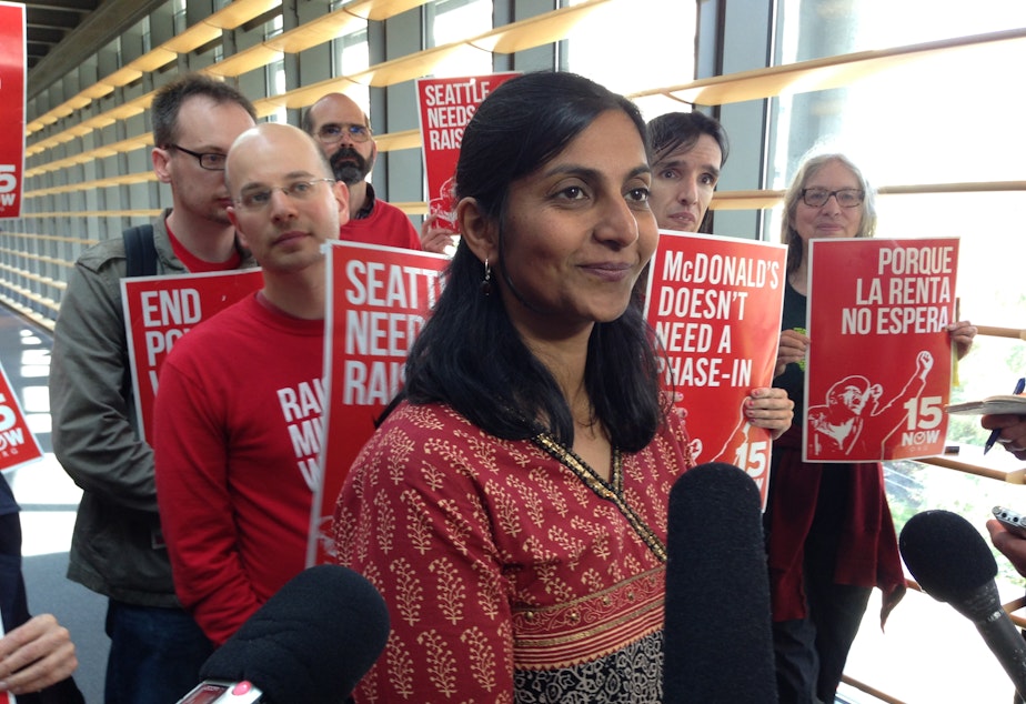 caption: Seattle City Councilmember Kshama Sawant meets with reporters after the vote to phase-in a $15 minimum wage.