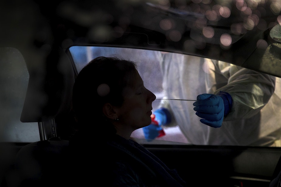 caption: Mark Radford, a paramedic with King County Medic One, administers a Covid-19 test on Wednesday, November 18, 2020, in the parking lot of the Weyerhaeuser King County Aquatic Center along Southwest Campus Drive in Federal Way.