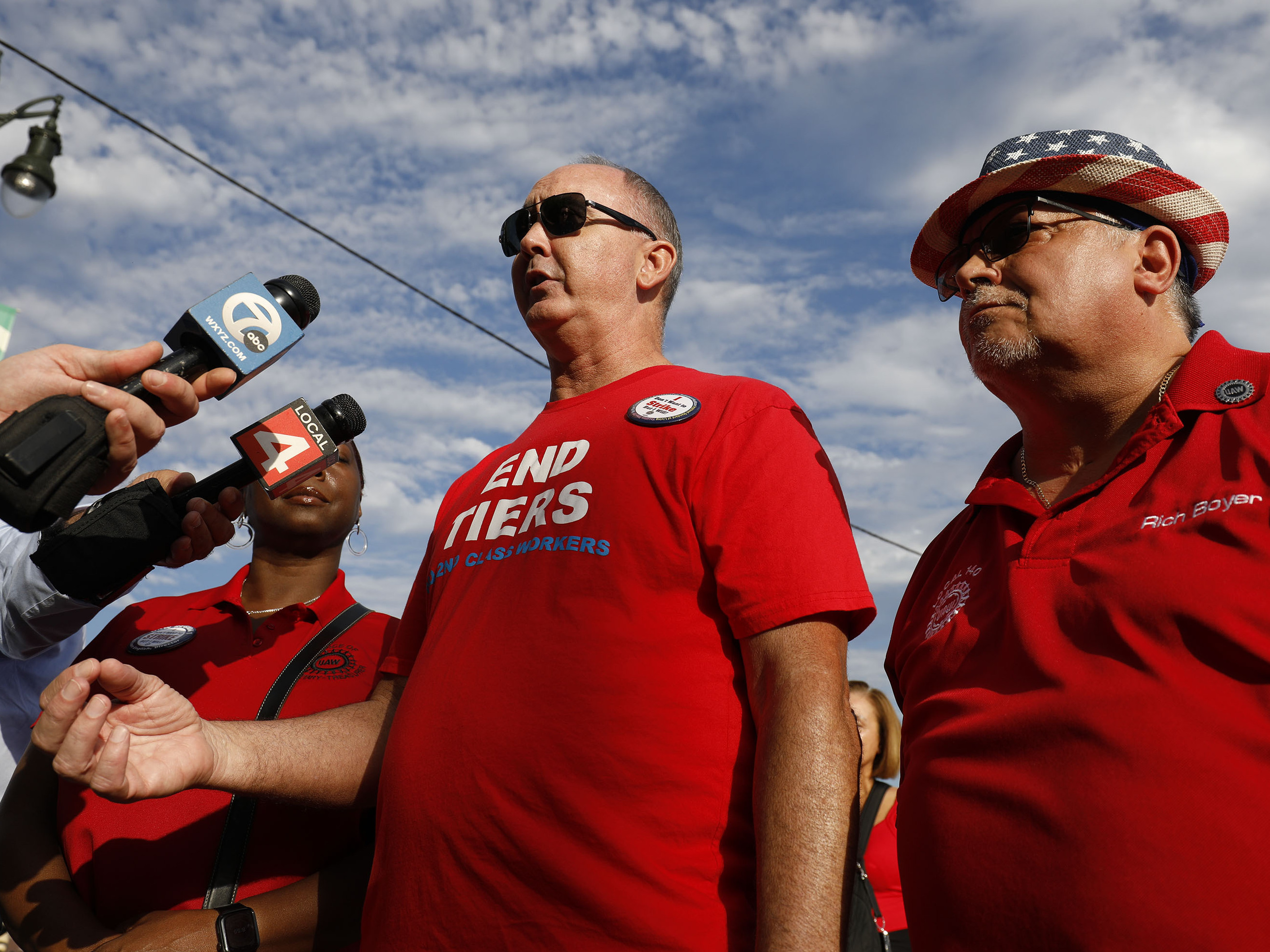 caption: United Auto Workers President Shawn Fain talks with the news media before marching in the Detroit Labor Day Parade on September 4, 2023 in Detroit, Michigan.
