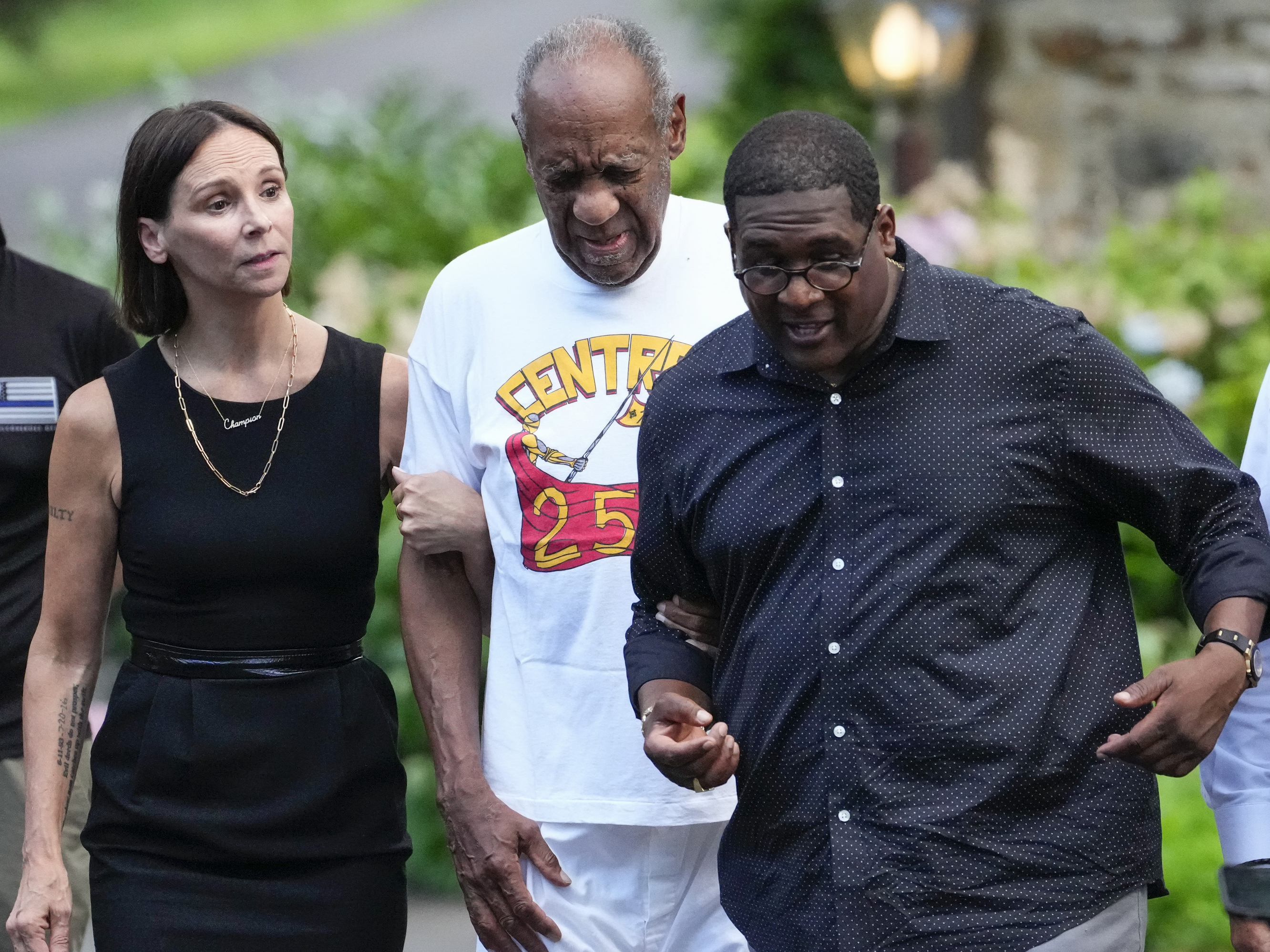 caption: Bill Cosby (center) approaches members of the media gathered outside his home in Cheltenham, Pa., with his spokesperson Andrew Wyatt. On Wednesday, Pennsylvania's highest court overturned Cosby's sex assault conviction, and he was released from prison.