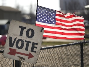 caption: In one of the contests ahead of Super Tuesday on March 5, a vote sign and American flag are shown outside a Michigan primary election location in Dearborn, Mich., on Feb. 27.