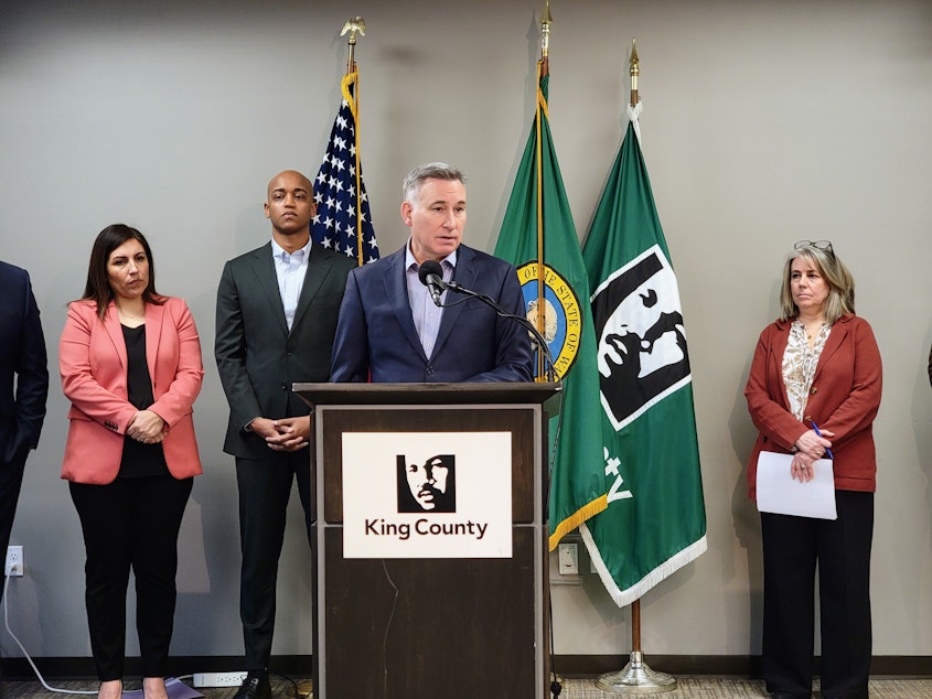 caption: King County Executive Dow Constantine stands with members of the County Council and public health community at a press conference on Monday, March 4, 2024.